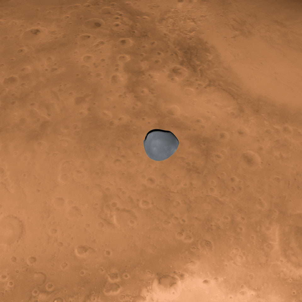 In this false-color image, the dark, irregularly shaped Martian moon Deimos is silhouetted against the brighter backdrop of Mars.